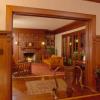 Night view of restored living room taken from dining room shows restored woodwork and tile fireplace.