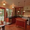 Kitchen expanded into new bump-out.  Highlight is a beautifully restored Wedgwood range on far wall.  Walls are bead board.  Cabinets are a lightly stained cherry with black Richlite countertops.  Oak flooring is continuous on first floor.