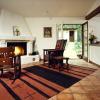 Opposite view shows a large corner fireplace, focal point of the room. To the right is an open counter and kitchenette.  Through French doors we see new garage that is attached to main house.